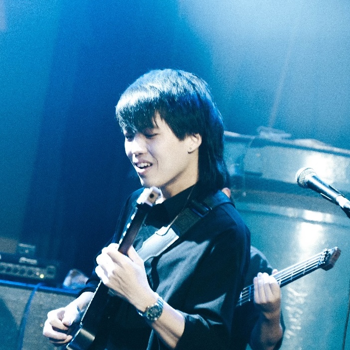 Barry Cheng playing guitar on stage